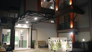 A hotel entrance with a sign reading "FLORAL SHIRE," a staircase, and a bench outside. - L42 Hostel (Bangkok)