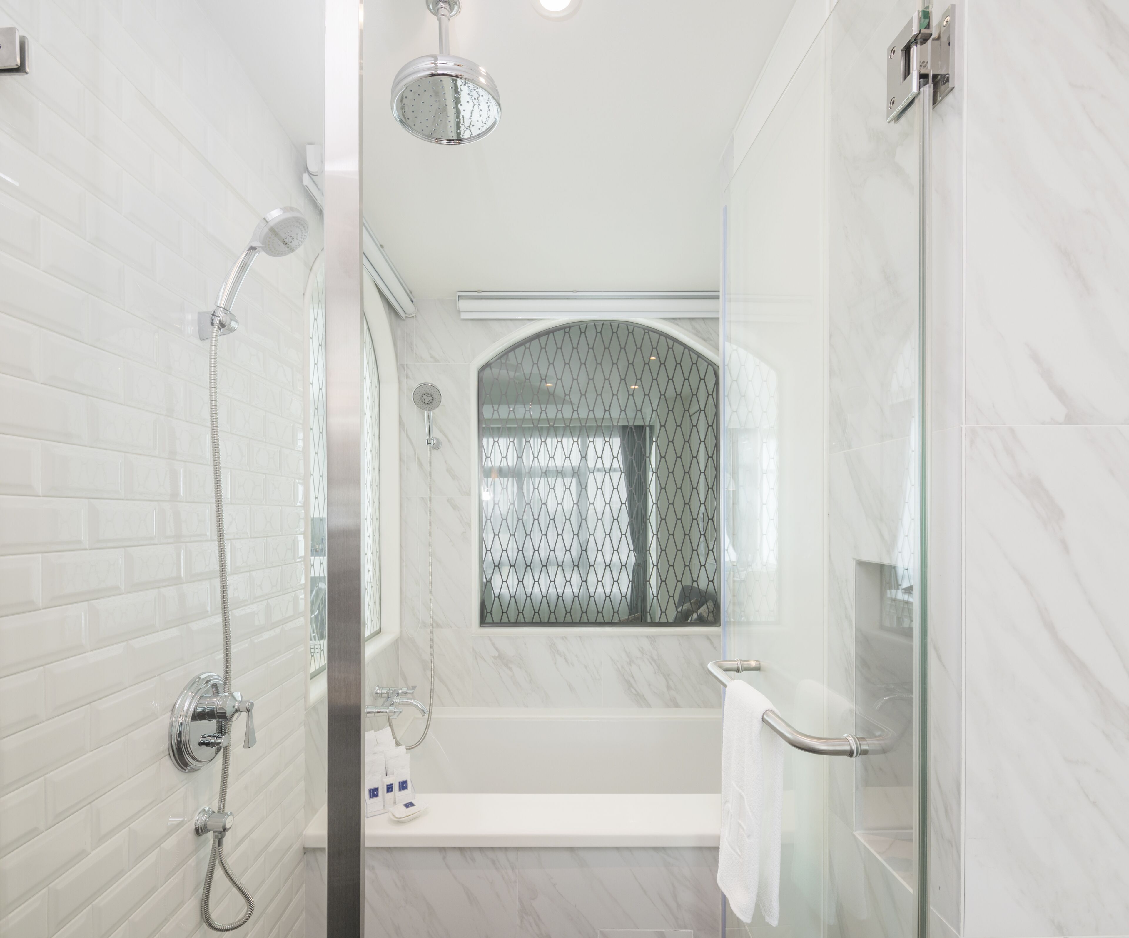 A modern bathroom with a glass shower enclosure, a bathtub, and a toilet.