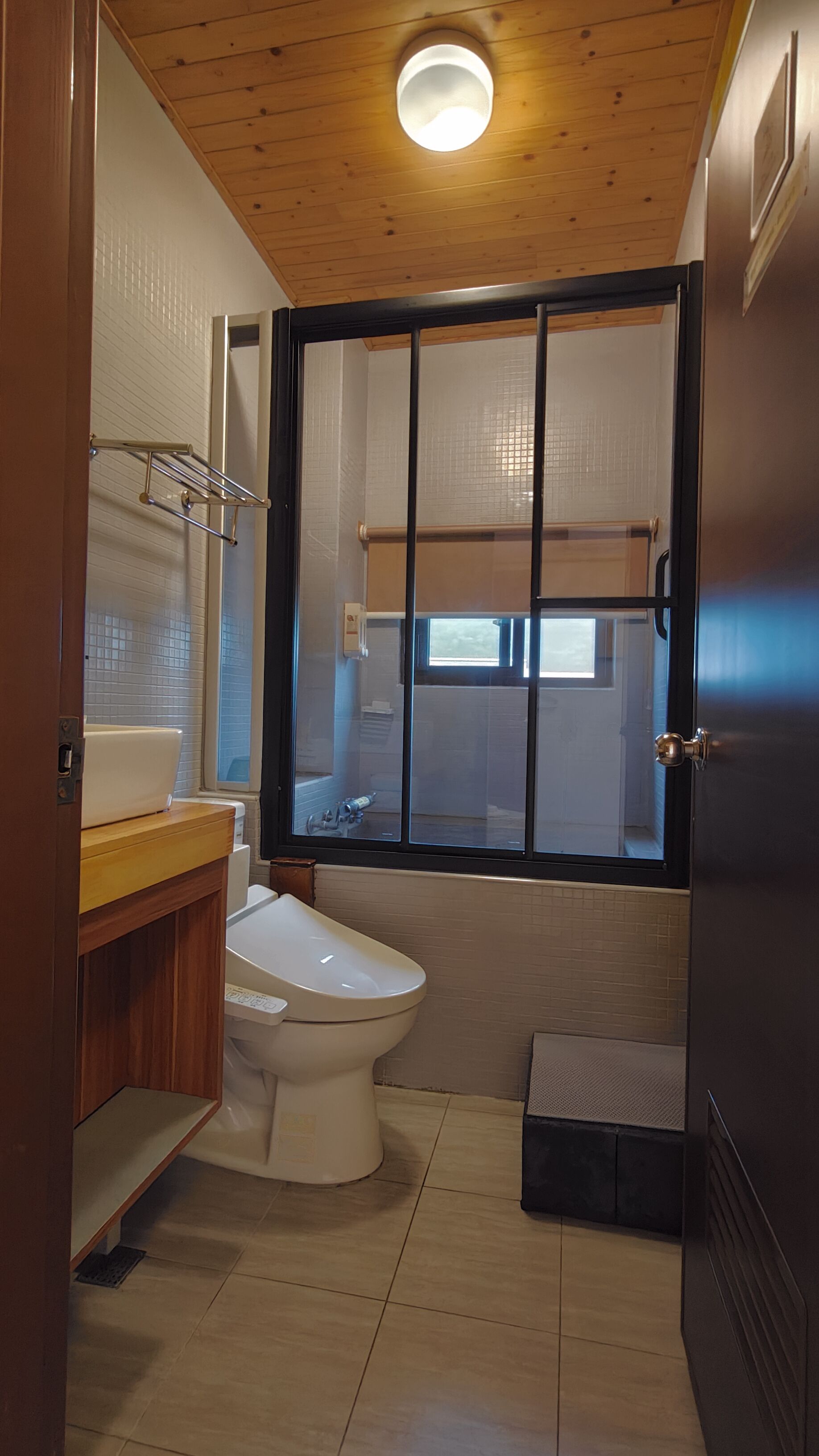 A compact bathroom with a toilet, sink, and window.