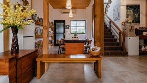 A spacious kitchen with a wooden dining table, a built-in bench, and a large window. - Tian Yan Mountains (Jiaoxi)