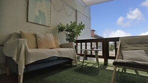 A cozy outdoor seating area with a sofa and a chair, a small table, and a potted plant. - Tian Yan Mountains (Jiaoxi)