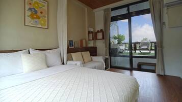 A hotel room with a large bed, a smaller bed, a wooden ceiling, a window with curtains, and a view of the outdoors.