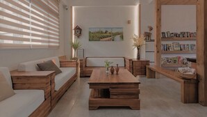 A modern living room with a wooden sofa, a coffee table, and a bookshelf. - Tian Yan Mountains (Jiaoxi)