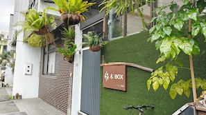 A building with a green wall, a sign reading "WOOD BOX," and hanging plants. - Tian Yan Mountains (Jiaoxi)