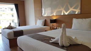 A hotel room with two beds, a large window, a wall-mounted lamp, and a decorative wall panel. - The Vista Hotel (Sadao)