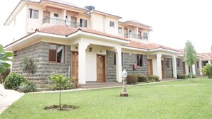 A two-story hotel with a stone facade, multiple balconies, and a well-maintained lawn. - Bondo Pride Hotel (Bondo)