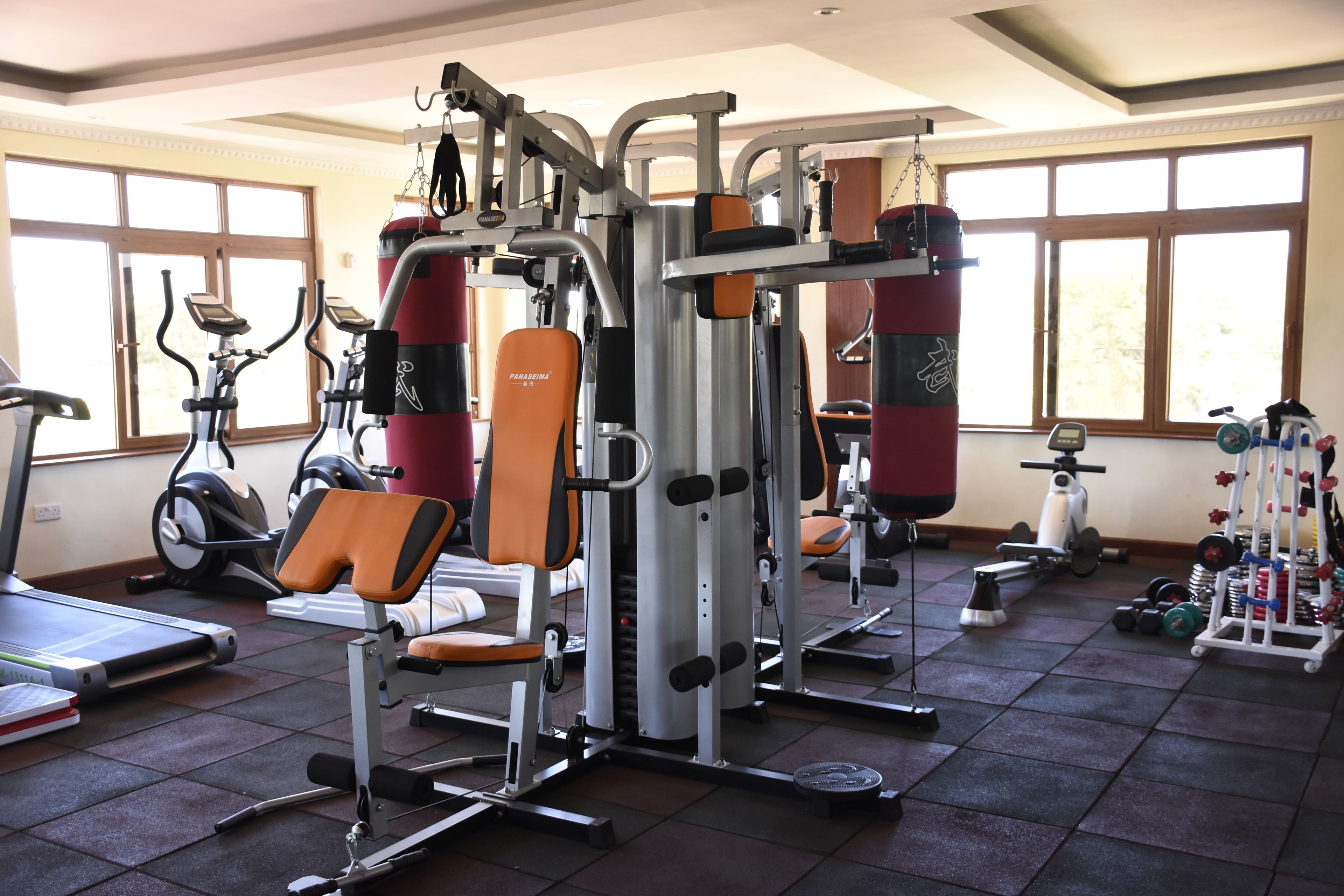 A gym with various exercise equipment, including a treadmill, stationary bikes, and weight machines.
