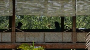 Une pièce dotée d’un plafond en bois et offrant une vue sur une végétation luxuriante.