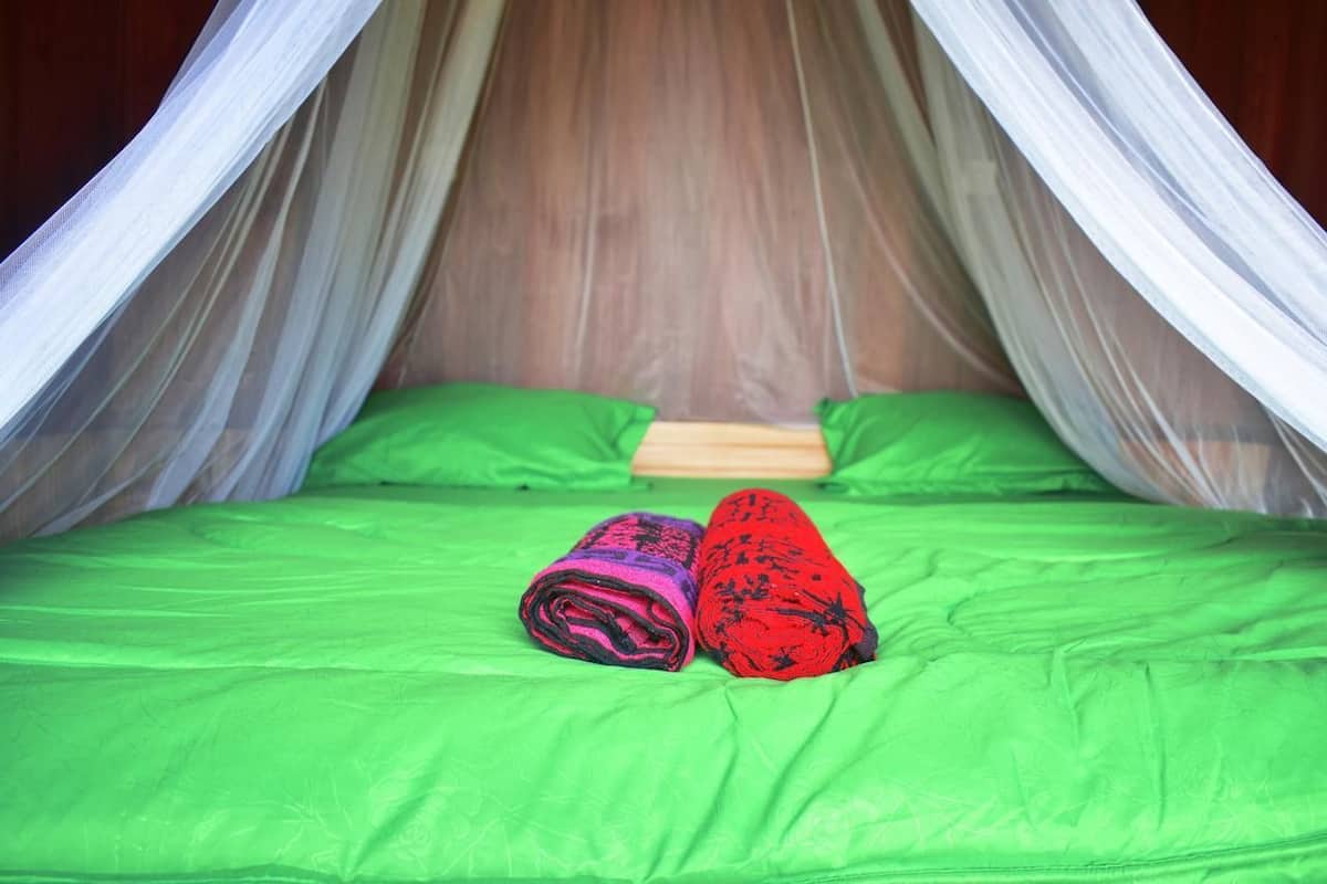 Ein Bett mit einer grünen Matratze und einem Baldachin.