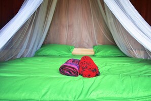 Un lit avec un matelas vert et un baldaquin.