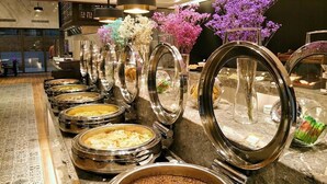 Un área de bufé con varios platos redondos de servicio y una gran variedad de alimentos.
