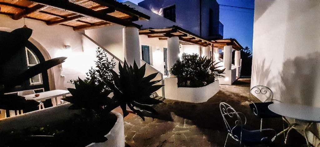 A courtyard with a pergola, potted plants, and outdoor seating.