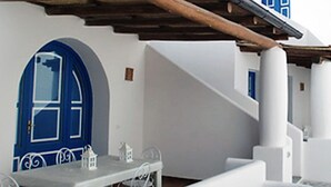 Um edifício branco com porta azul e colunas.