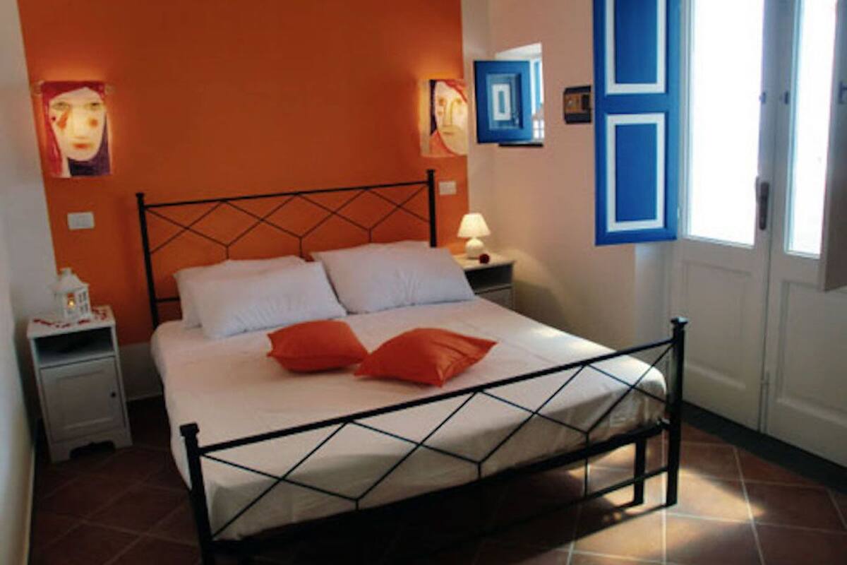 Un dormitorio con cama, mesitas de noche y una puerta.