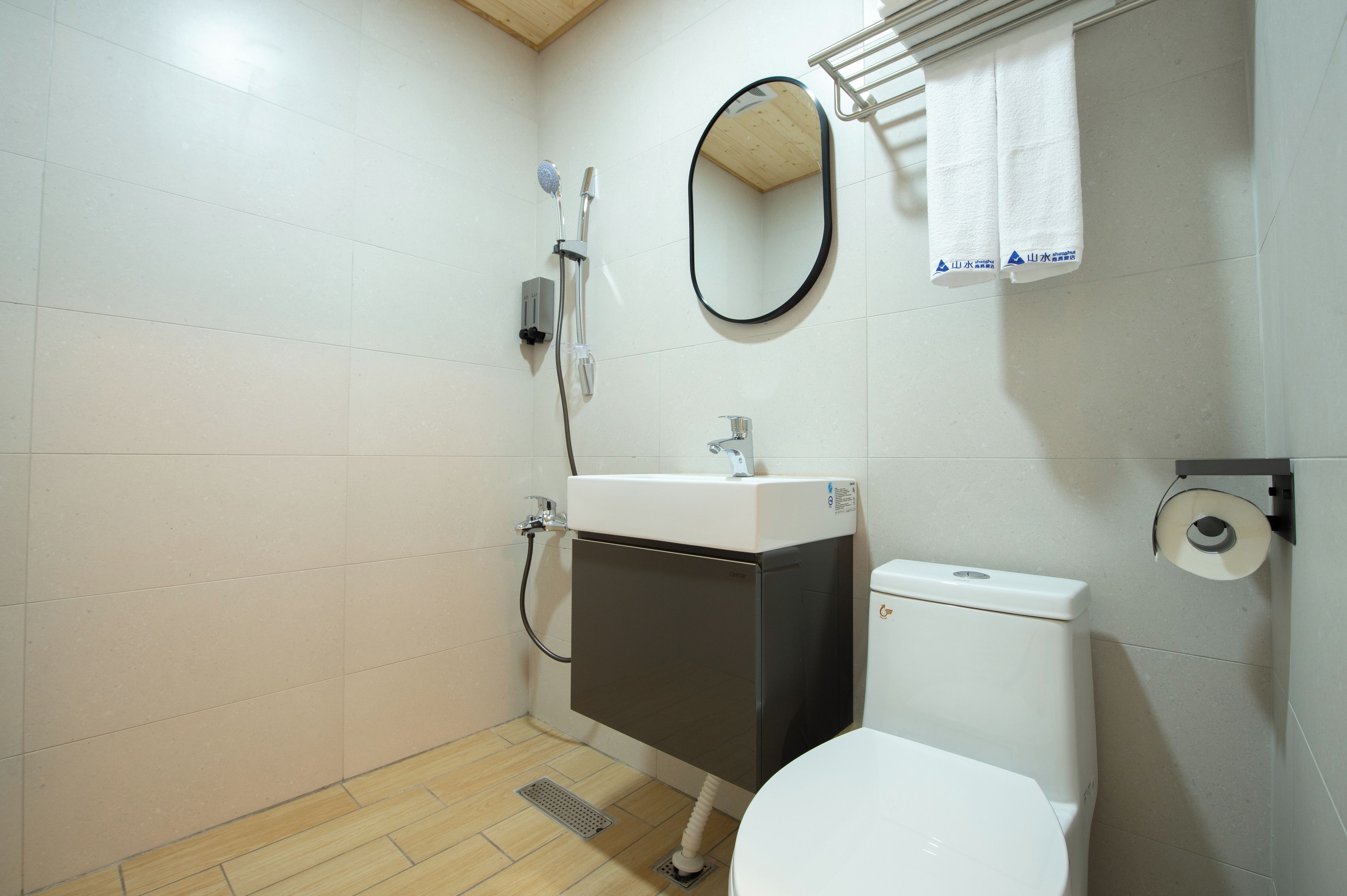 Un baño con inodoro, lavamanos, espejo y ducha.