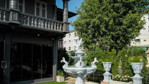 A building with a fountain in the courtyard, surrounded by a well-maintained lawn and stone pathways. - The O-Zone Airport Inn (Bangkok)