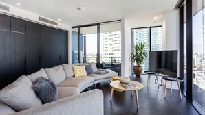 Una sala de estar moderna con un sofá, una mesa de centro y un televisor.