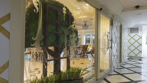 A modern interior with a glass partition, a dining area, and a patterned floor. - Orchid Resort (Bangkok)