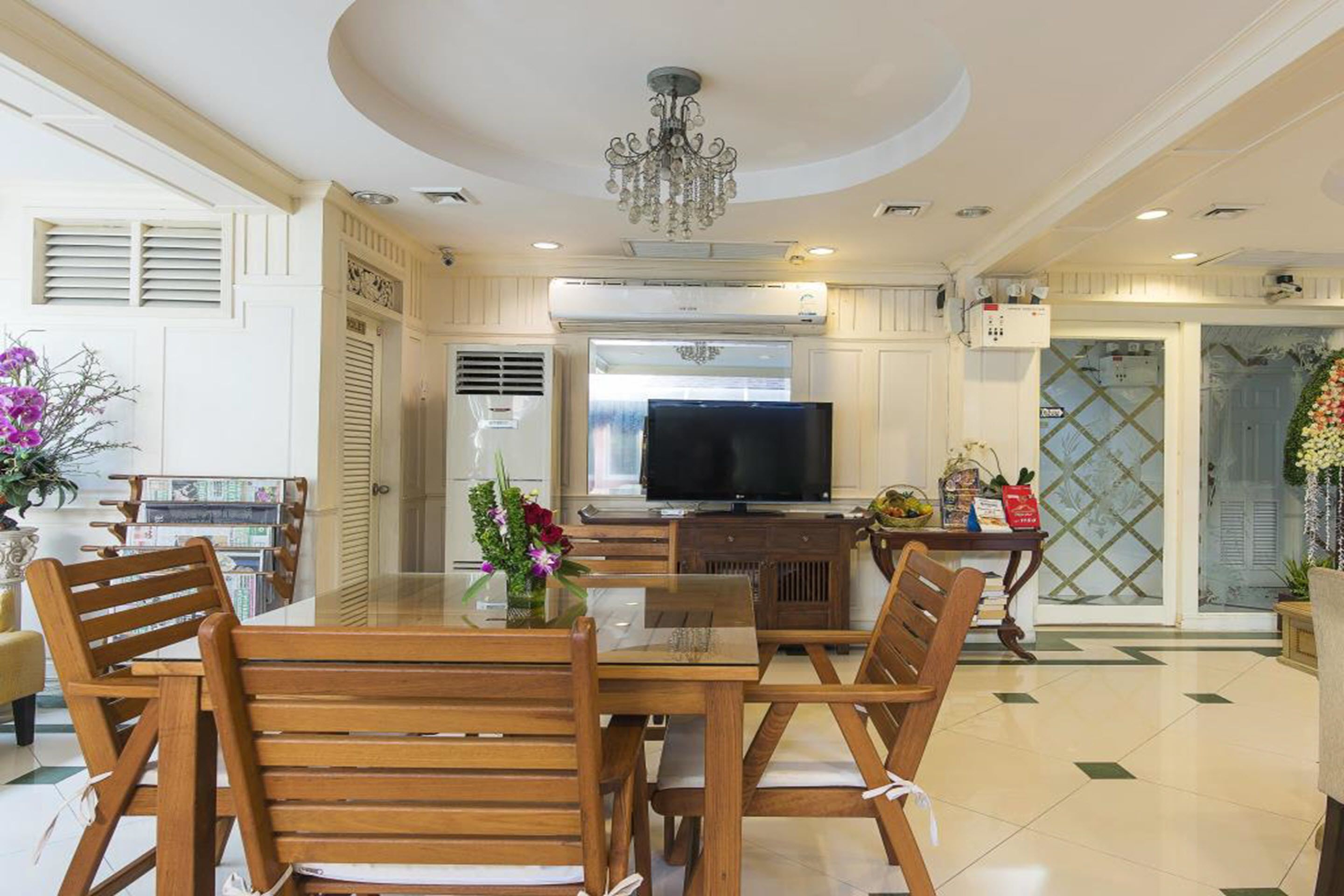 A modern kitchen with a central island, a built-in oven, and a large flat-screen TV.
