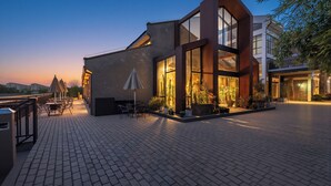 A modern building with large windows, outdoor seating, and potted plants. - Lin Yin Art Hotel Shanghai PVG Airport Disneyland Free Shuttle (Shanghai)