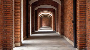 A corridor with brick walls and white arches, leading to a dark area at the end. - Melia Shanghai Parkside (Shanghai)