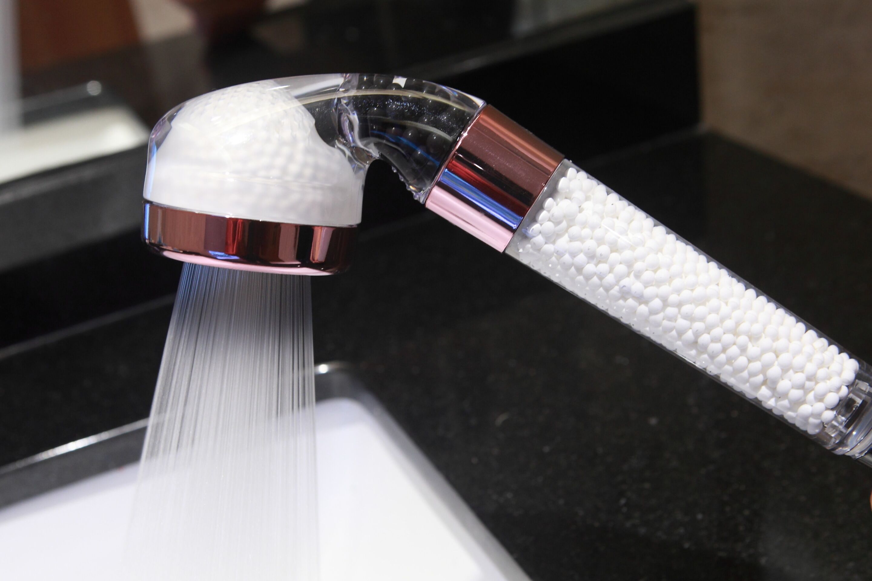 A modern kitchen faucet with a transparent handle and a white textured grip.