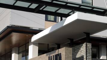 Un edificio moderno con una entrada destacada, un letrero que dice "LA LUCA" y una marquesina.
