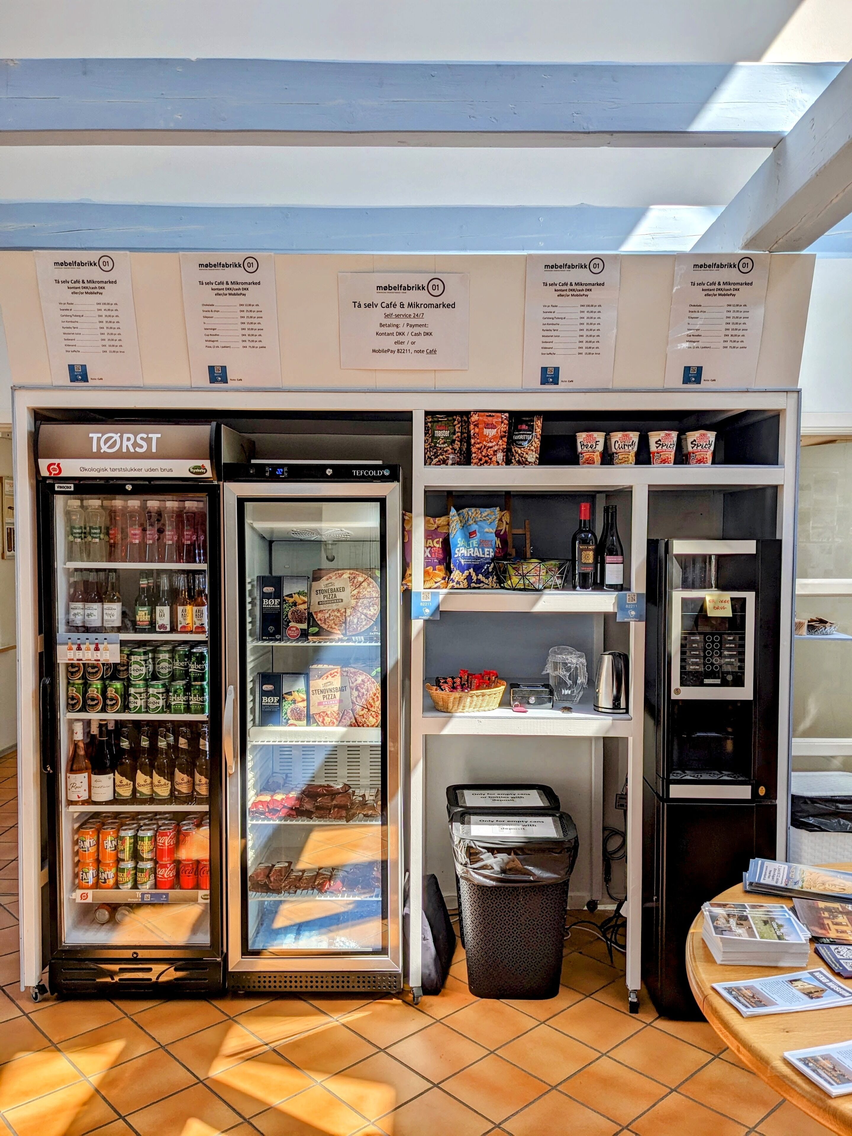 Una distribuzione automatica con bevande assortite, un congelatore con gelati e una selezione di snack e condimenti.