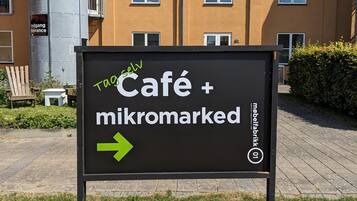 A sign for Café + mikromarked with an arrow pointing right.