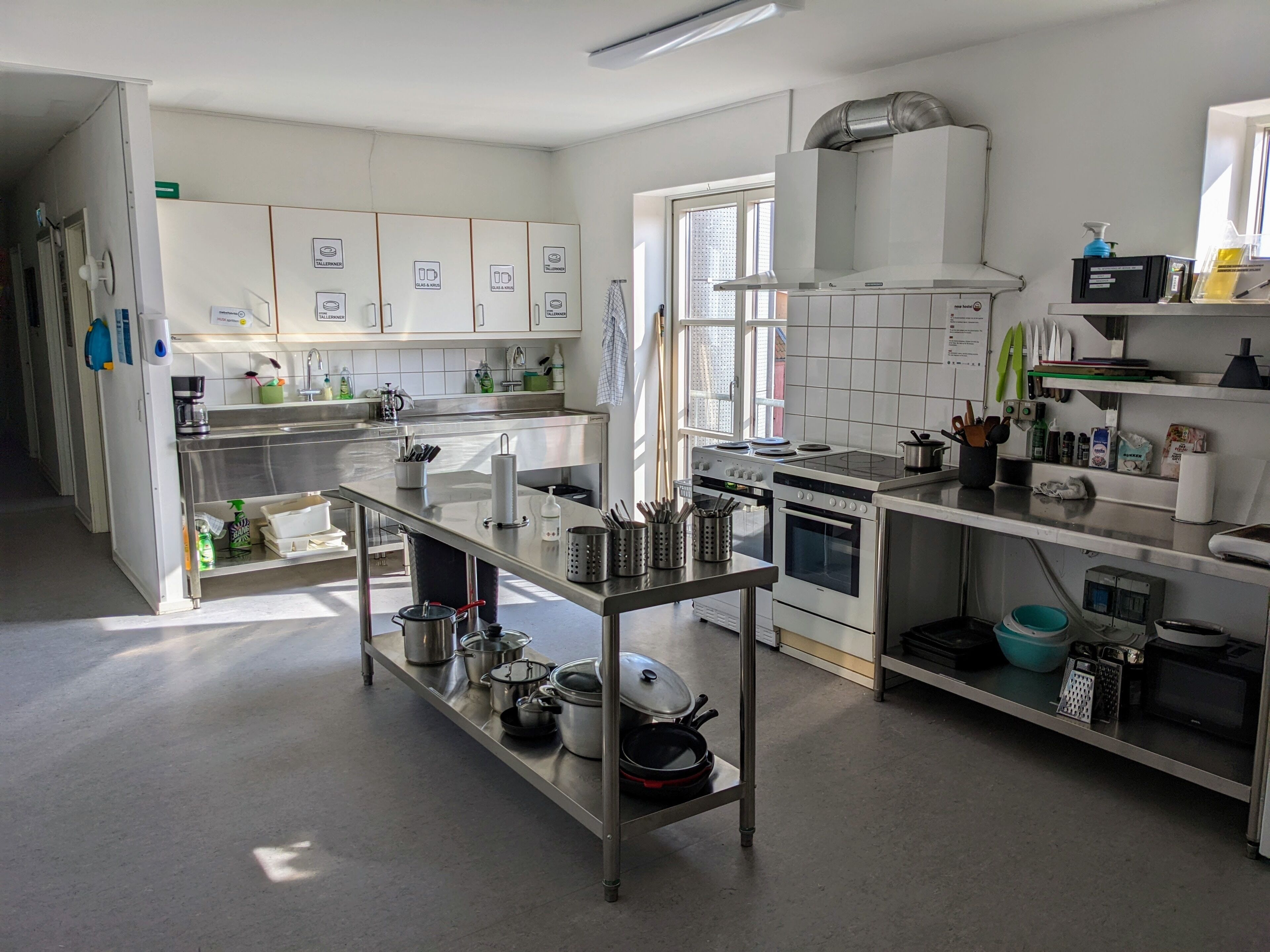 Une cuisine moderne dotée d’appareils électroménagers en acier inoxydable, d’un îlot central et de nombreux plans de travail.