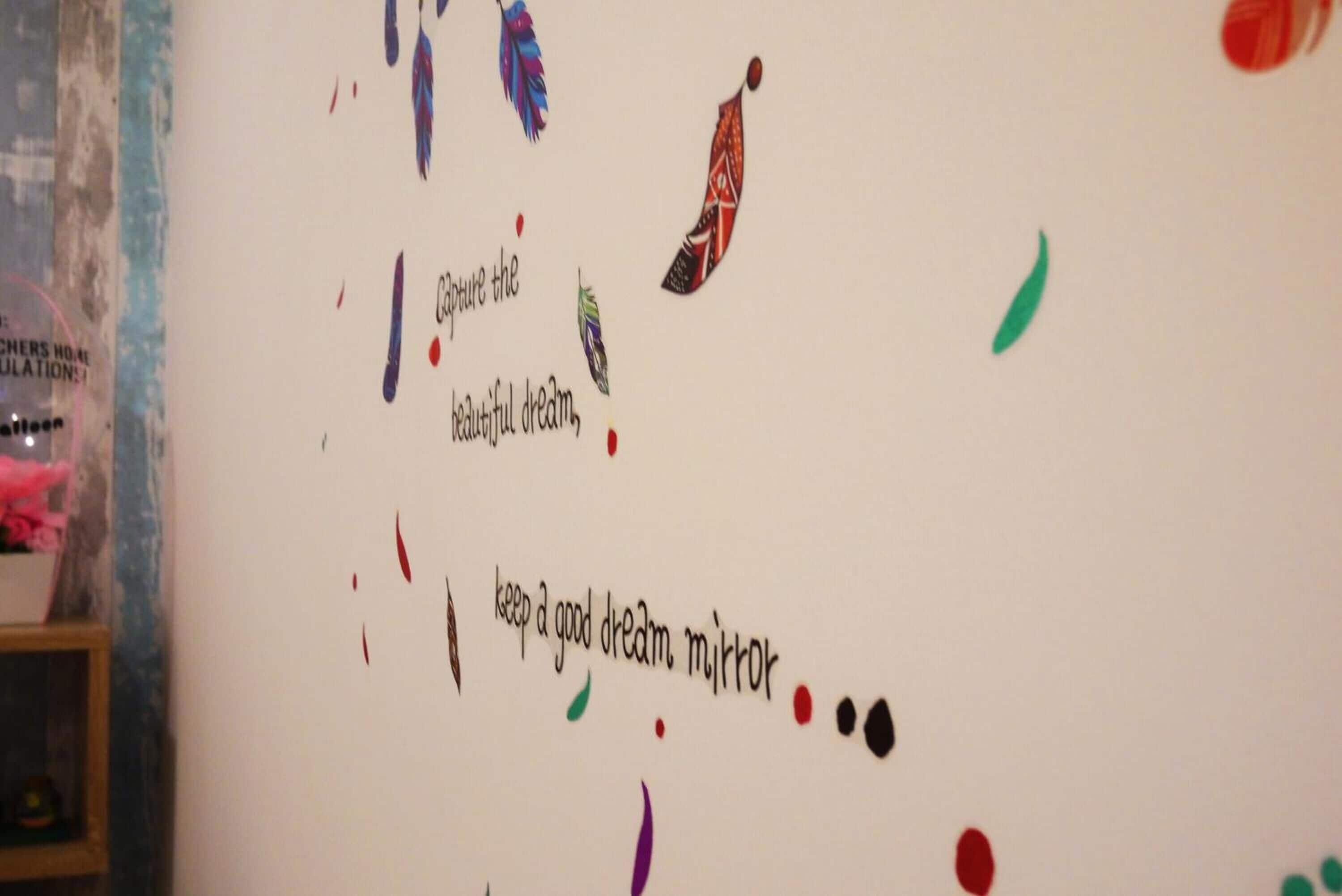 Una pared con frases motivacionales y decoraciones coloridas.