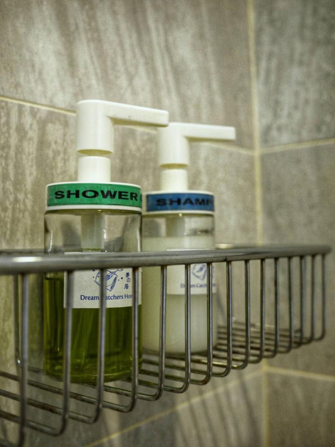 A bathroom shelf with two bottles labeled "Shower" and "Shami" and a Dream Catchers Home sign.