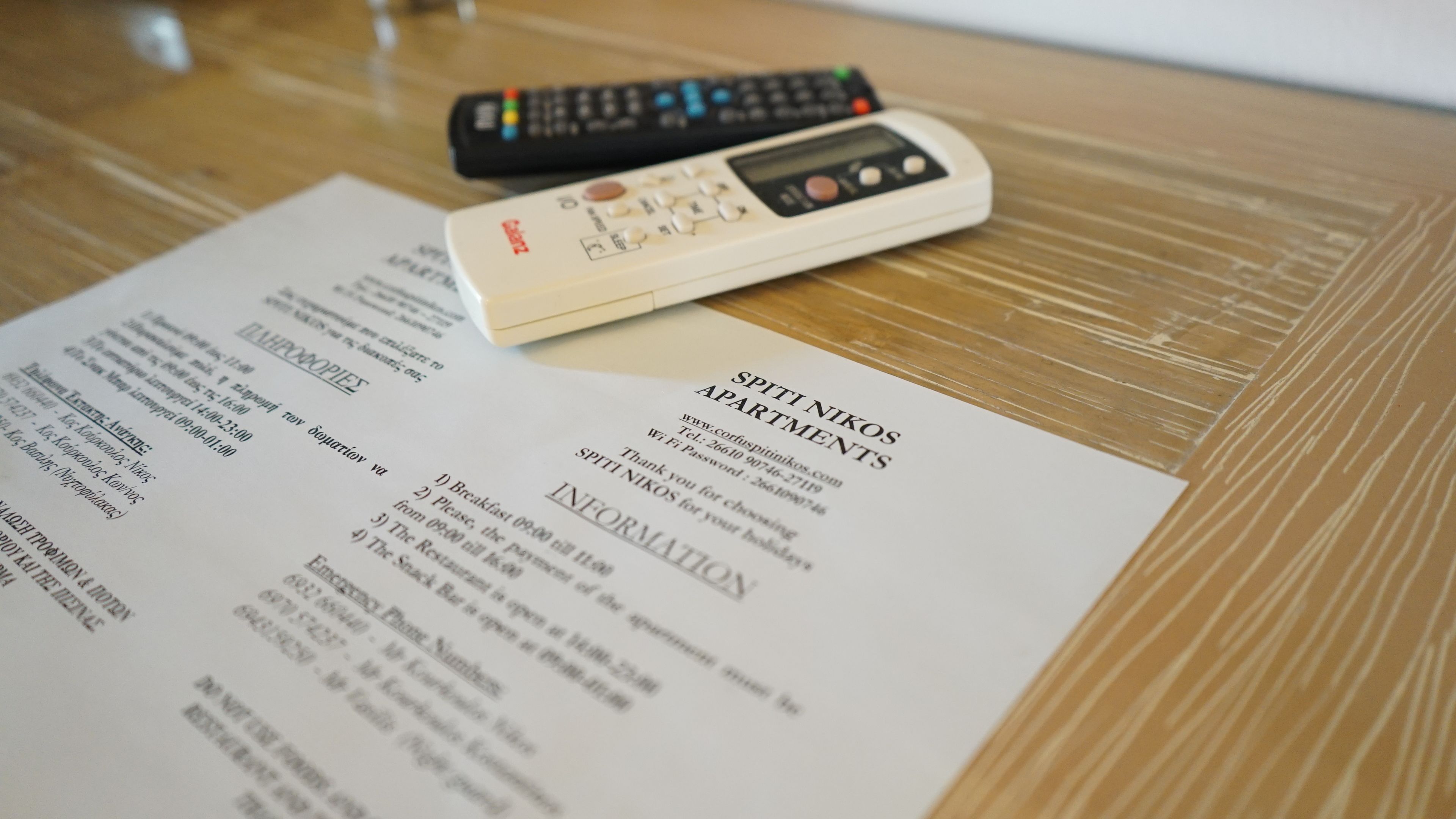 Un folleto de hotel con información sobre Spiti Nikos Apartments, que incluye servicios e información de contacto.