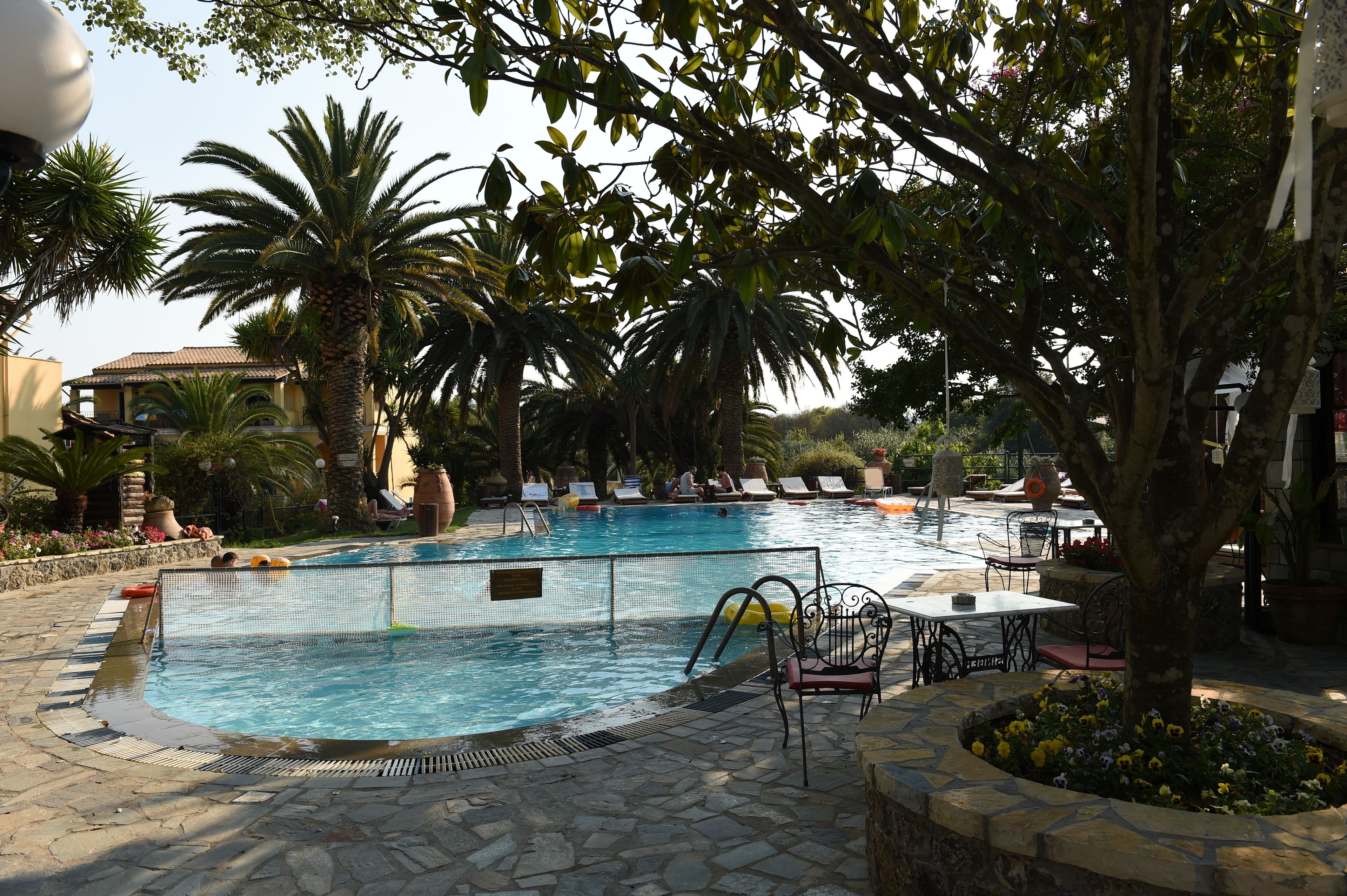 Une piscine avec des chaises longues et une terrasse en pierre.