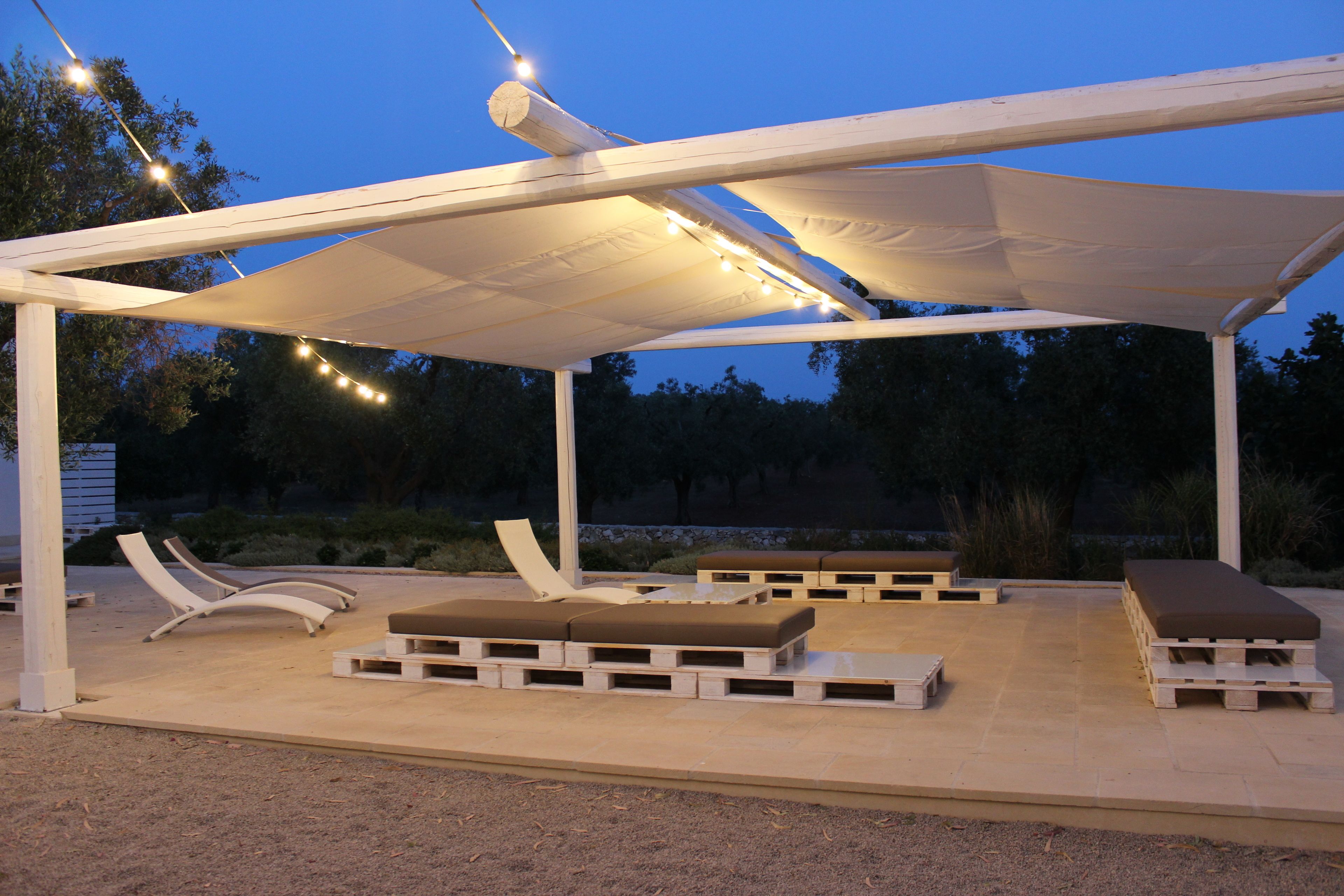 An outdoor patio with lounge chairs and a canopy.