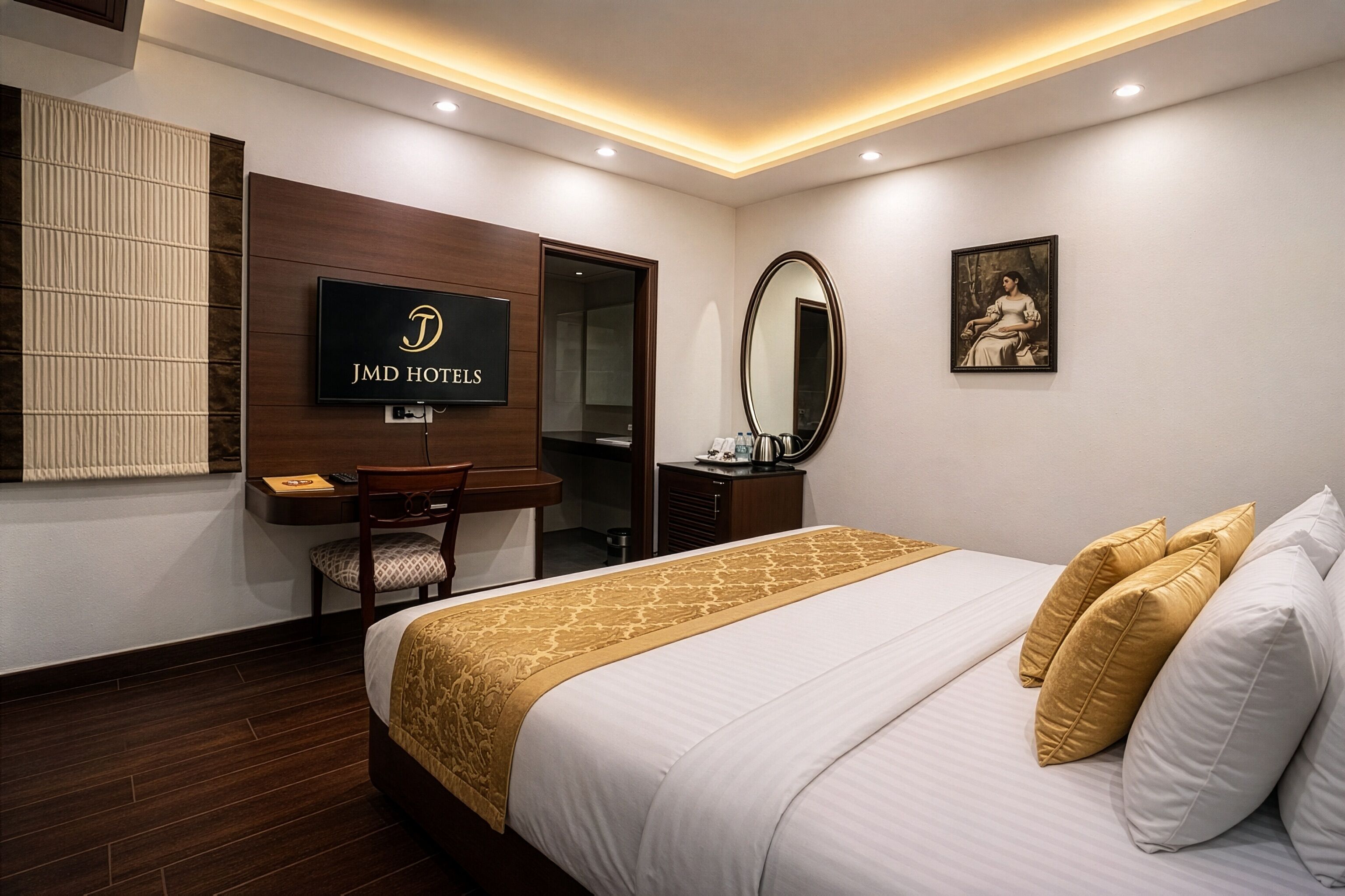 Une chambre d’hôtel avec un lit, un bureau, une chaise, un téléviseur fixé au mur et un tableau.