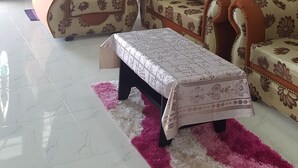 A living room with two sofas, a coffee table, and a rug. - JF Wadi Sofea Homestay (Kuala Terengganu)