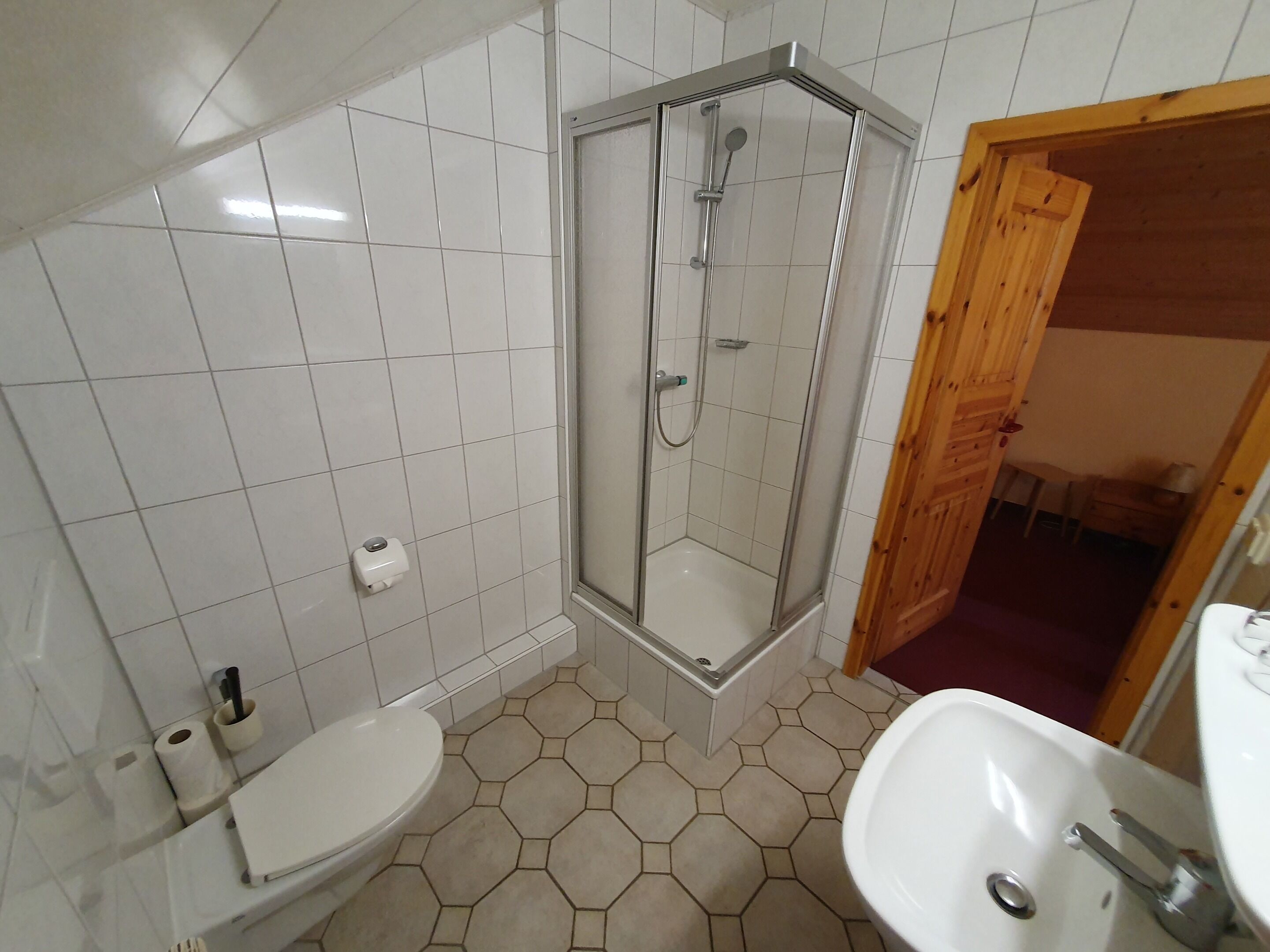 A bathroom with a shower, toilet, and sink.