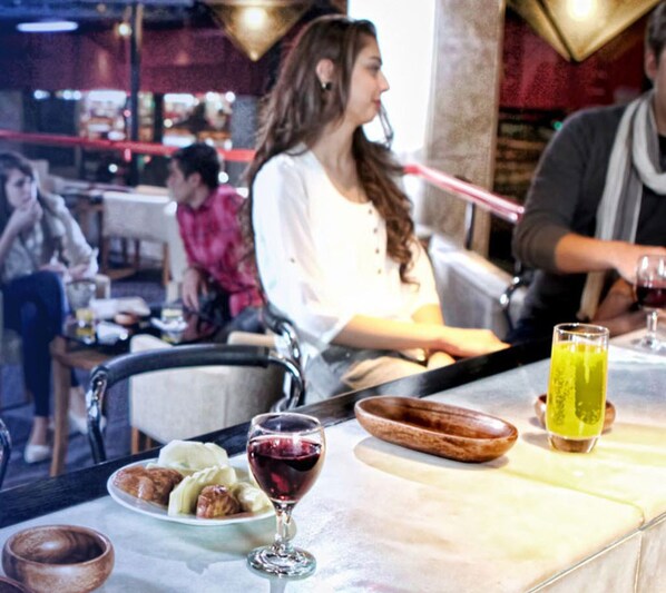 Un interior de restaurante con mesas, sillas y una zona de bar.