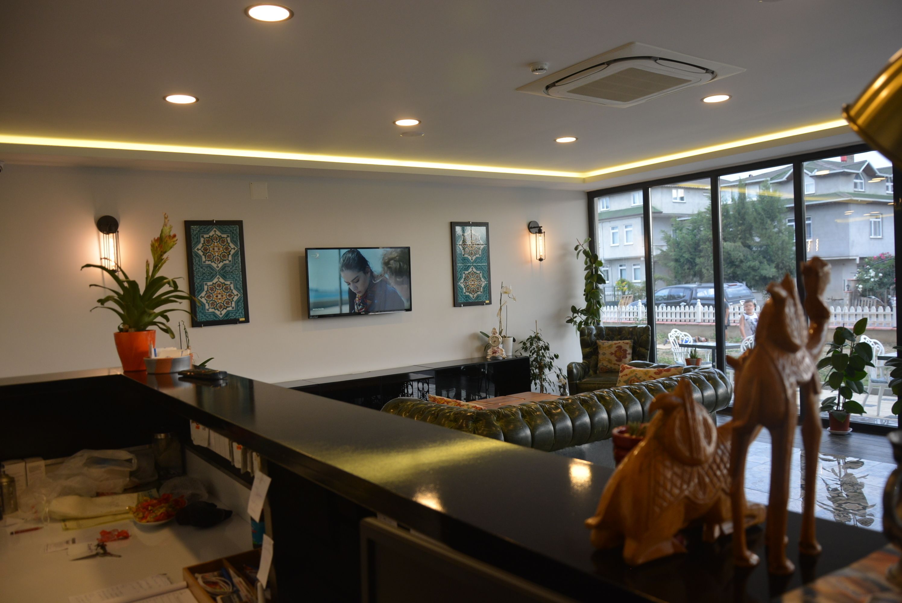 A modern interior with a black reception desk, a sofa, and decorative items.