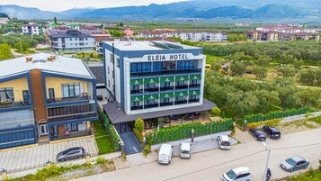 Un hotel de diseño moderno, con varios pisos y una terraza en la azotea.