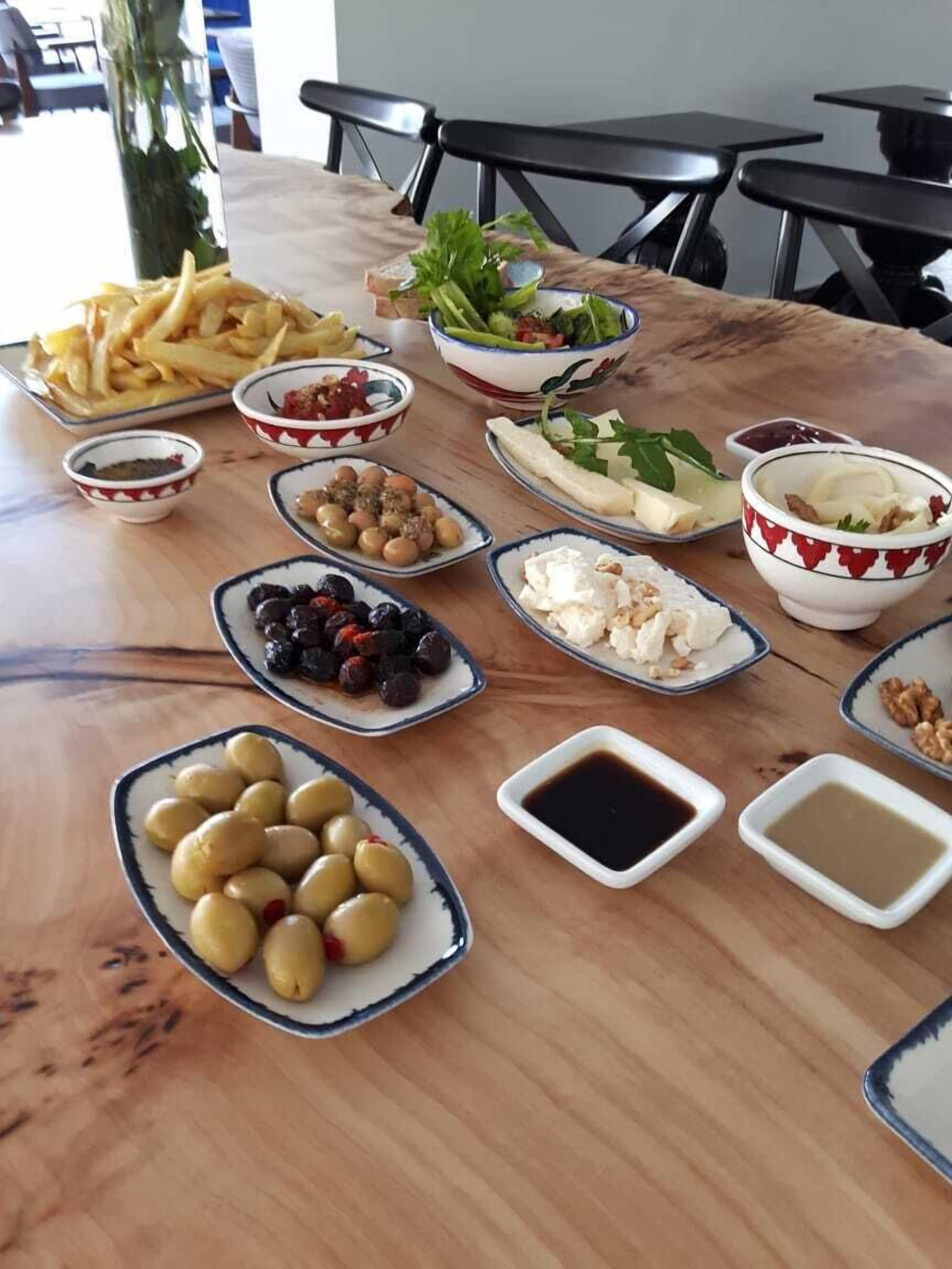 A table with various food items including olives, cheese, and salad.