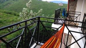 A balcony with a metal railing overlooking a lush green hillside. - Lago Resort (Kisumu)