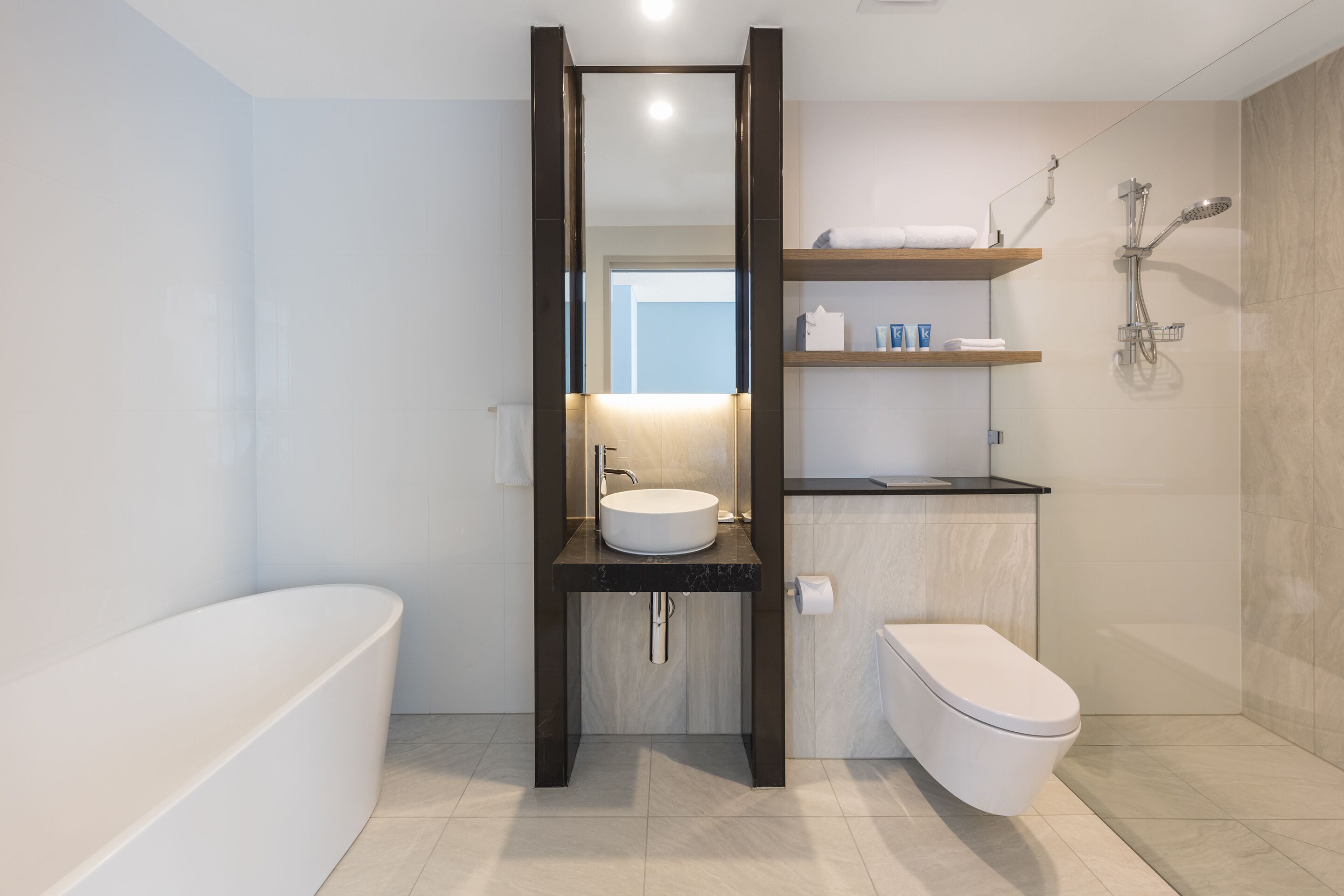 Une salle de bain moderne avec une baignoire sur pieds, un lavabo sur colonne et des toilettes.