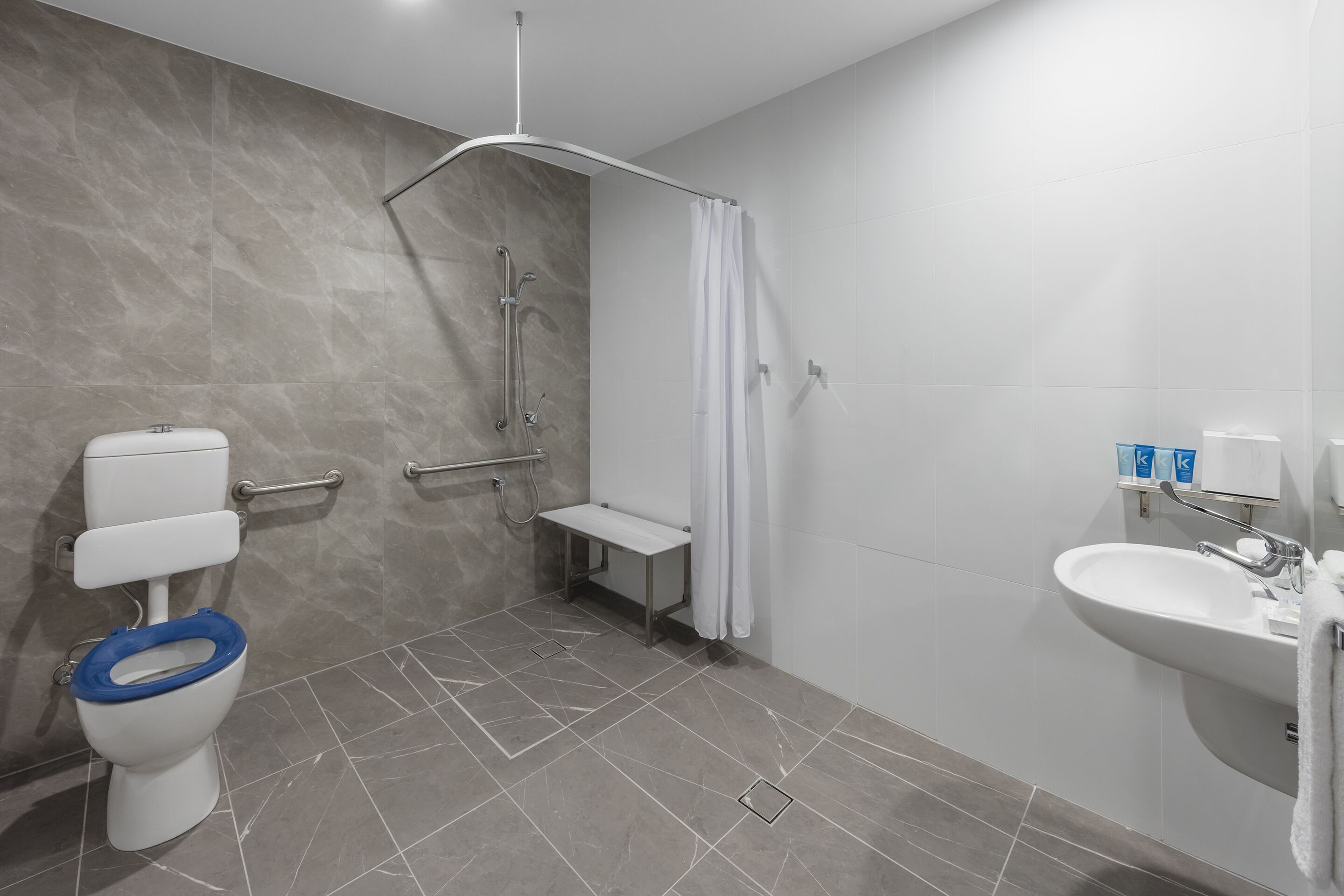 Une salle de bain moderne équipée de toilettes, d’une douche et d’un lavabo.