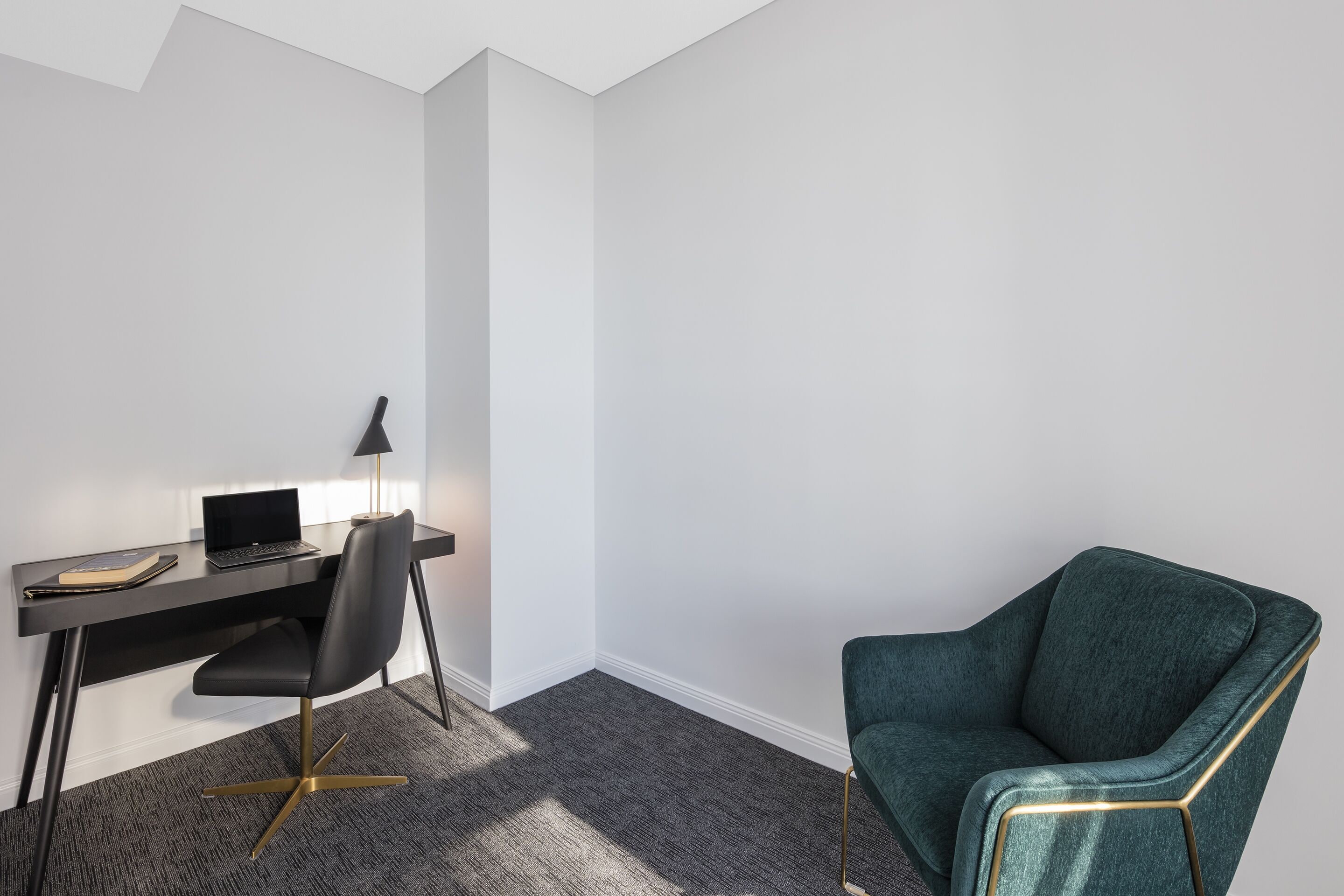 Un espacio de oficina moderno con un escritorio, una silla y un ordenador portátil.