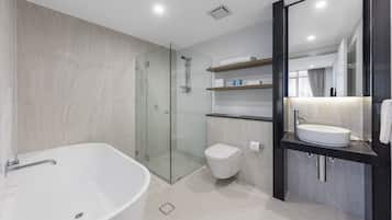 A modern bathroom with a freestanding bathtub, a glass-enclosed shower, a toilet, and a vanity with a sink and mirror.