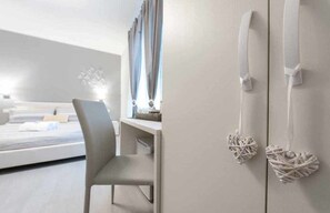 Habitación triple de diseño, varias camas | Edredones de plumas, minibar, escritorio y cortinas opacas