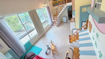 A multi-level interior with a staircase, a slide, and a play area.