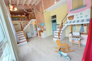 A multi-level interior with wooden floors, a staircase, a play area with toys, and a kitchen counter. - Village Villa B&B (Zhuqi)